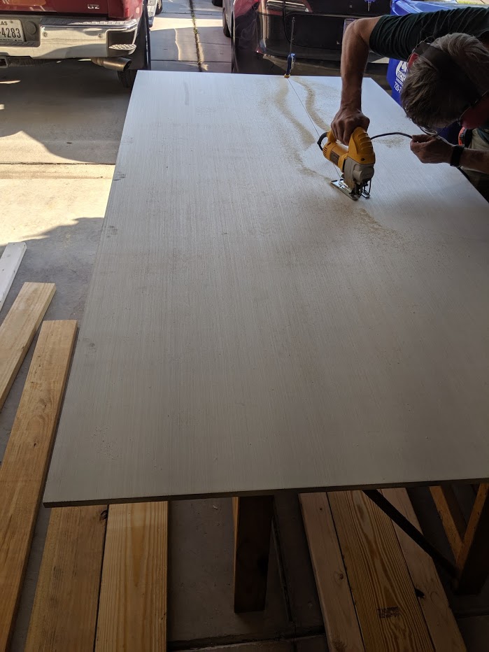 The sheet on the 8 foot wall was laid with a 16 inch radius (48 inch sheet width - 30 inches desk width) to make a smooth curve onto the 12 foot long wall section. We cut the curve with a sabre saw and outside the layout line and used an oscillating drum sander to smooth the cut to the line.